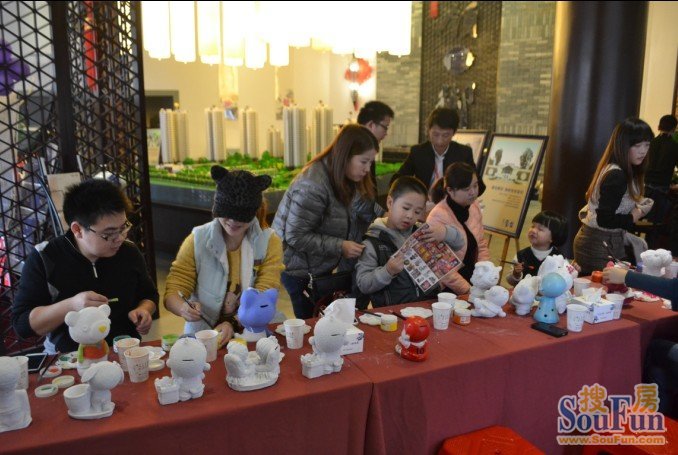 家长和孩子一起认真给陶瓷上色